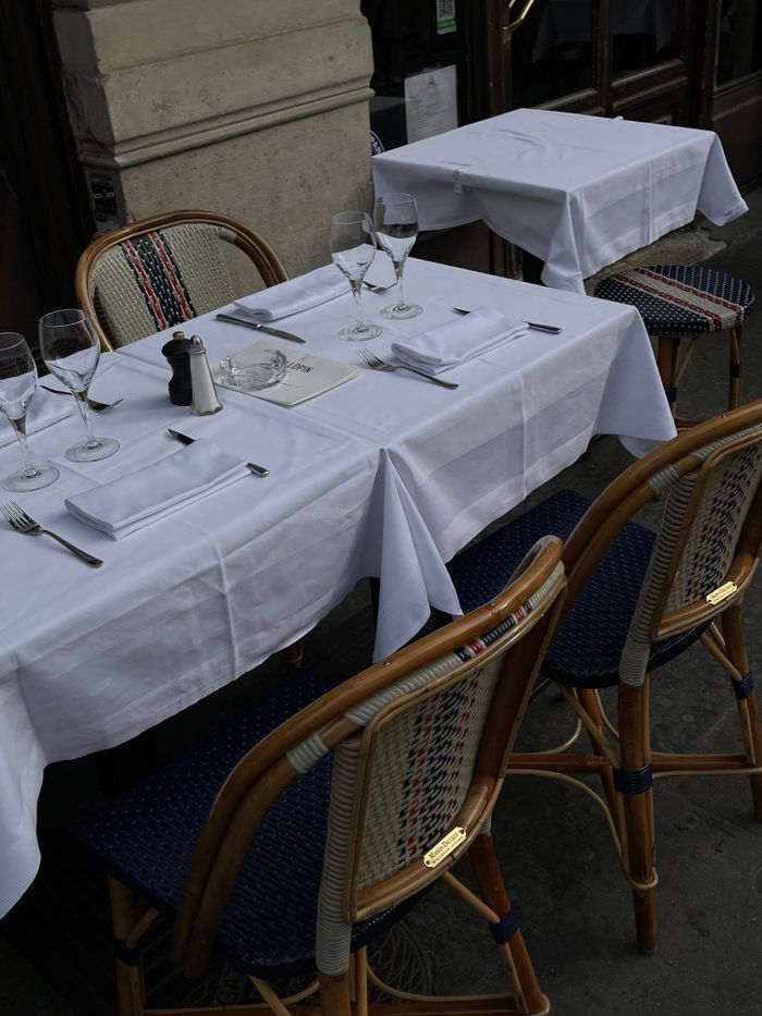 why-choose-us Chic outdoor restaurant setup with tablecloths, glasses, and rattan chairs.