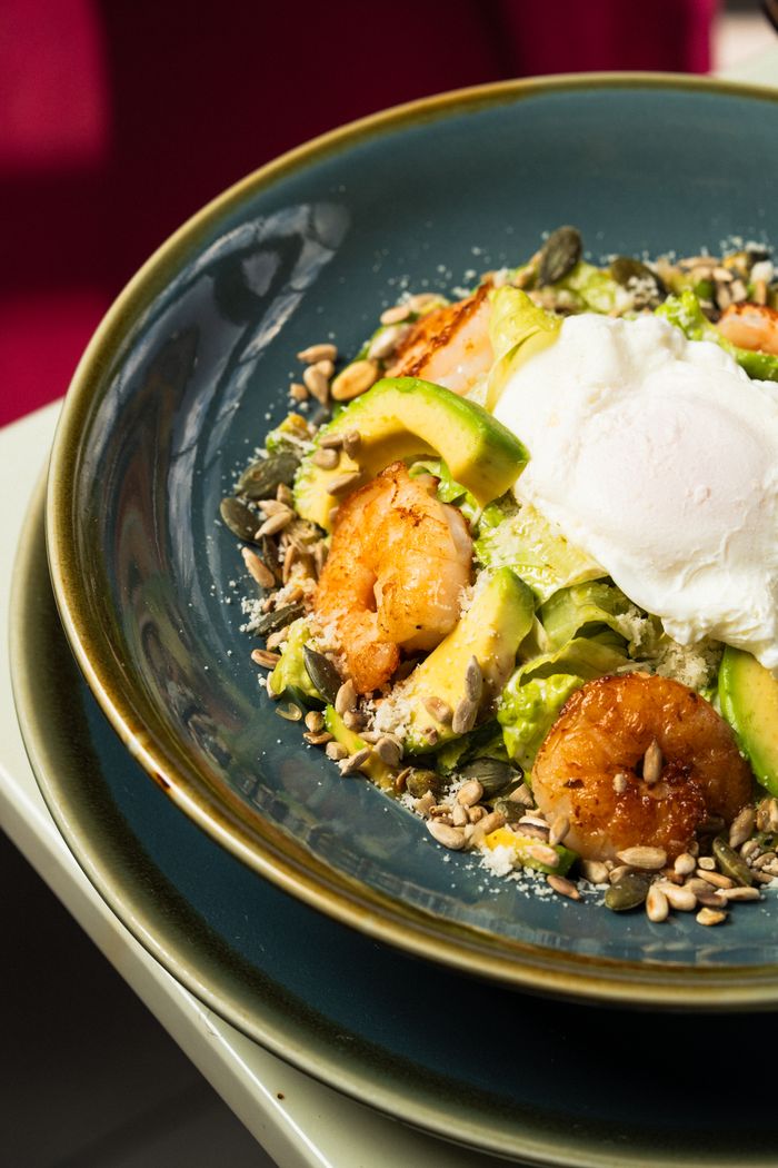 gallery-6 Delicious shrimp avocado salad topped with a poached egg, vibrant and nutritious.