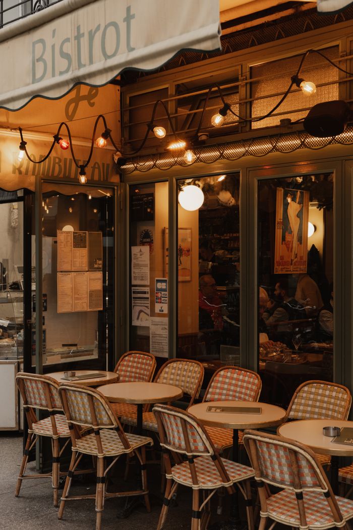 about-02 Paris bistro with outdoor seating, warm string lights, and cozy ambiance in the evening.